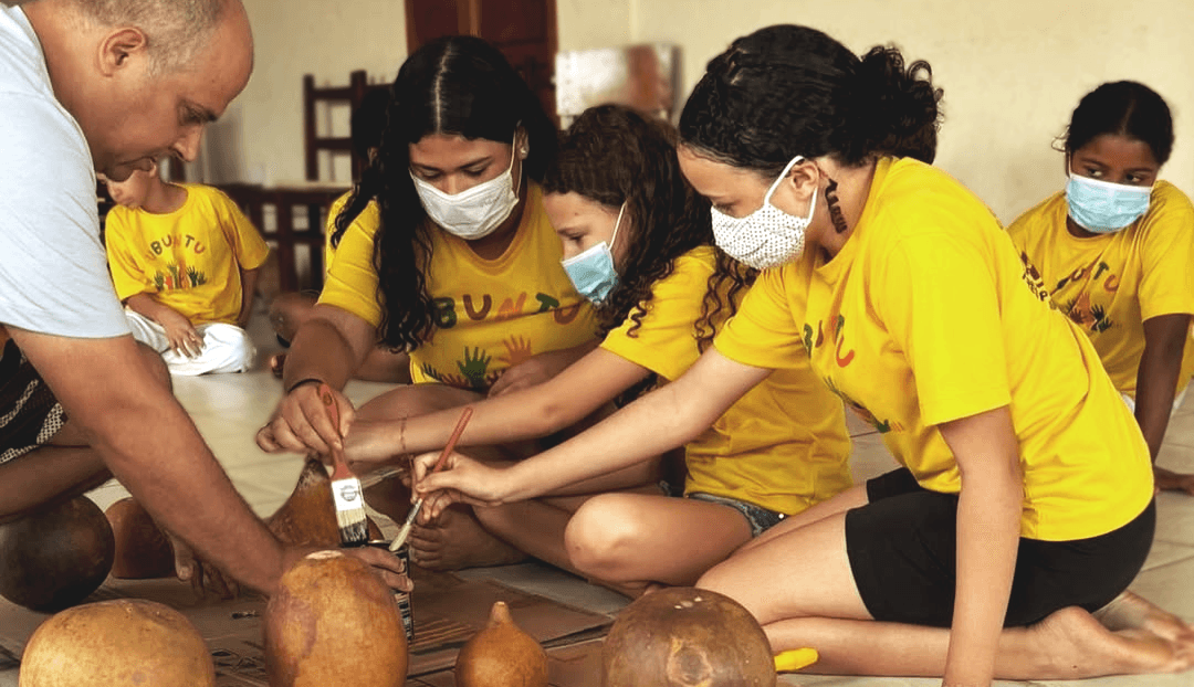 Professor ensinando as crianças a pintar.